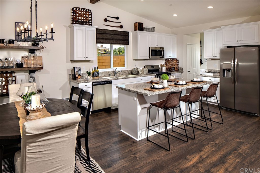 44402 Beringer Drive Indio, CA 92203 - Photo 7 of 18 a kitchen with stainless steel appliances granite countertop a stove a refrigerator a sink a stove and white cabinets with wooden floor