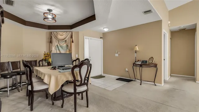 a view of a dining room with furniture and a chandelier