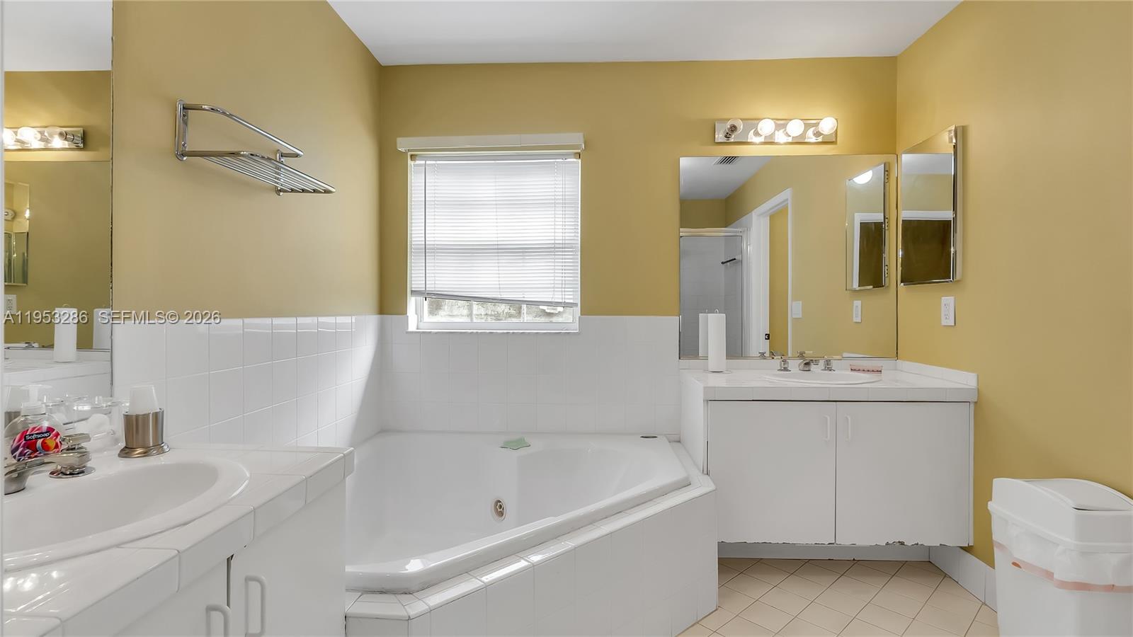 15486 Southwest 147th Street Miami, FL 33196 - Photo 17 of 30 a bathroom with a sink vanity tub and a mirror