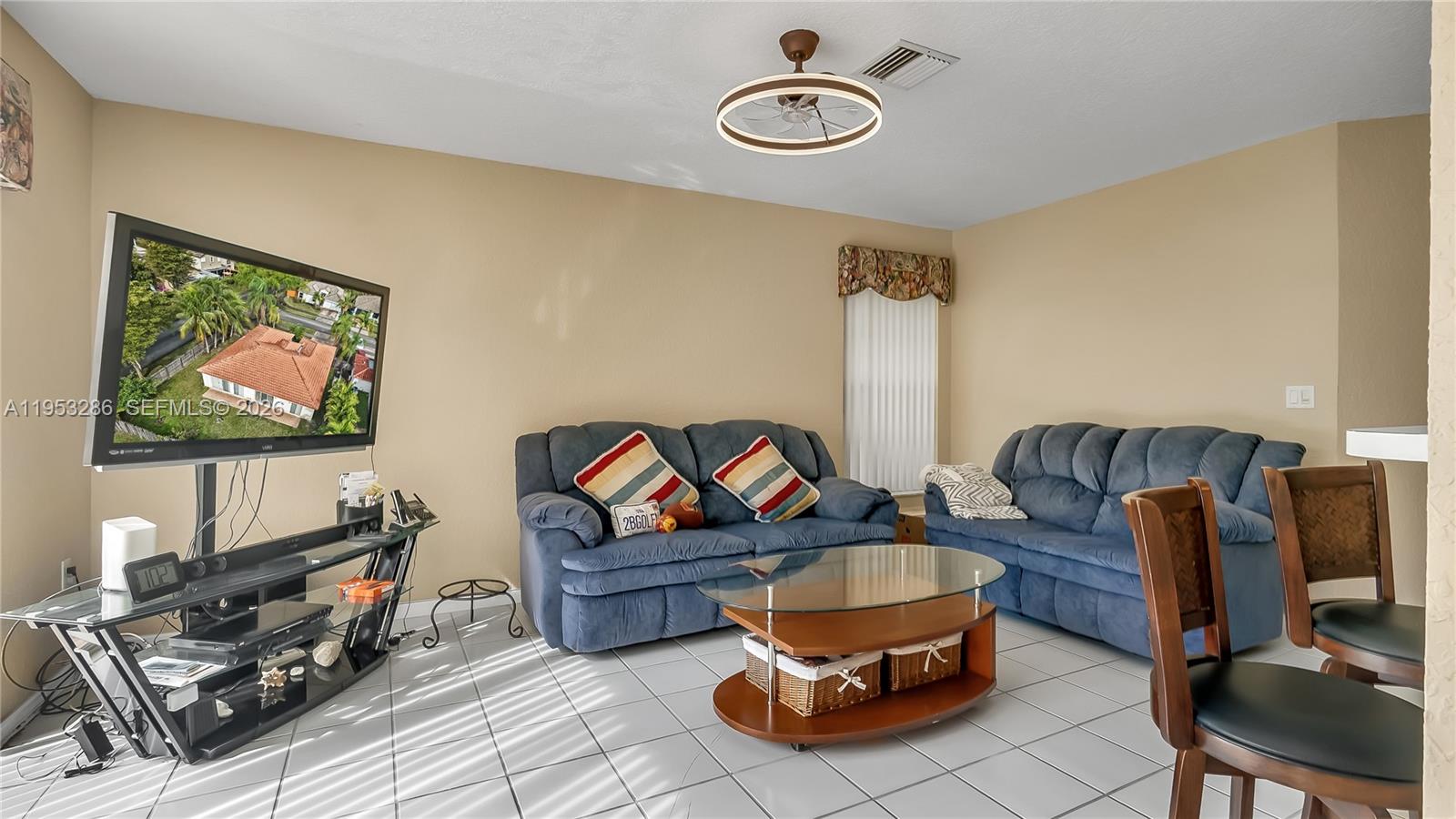 15486 Southwest 147th Street Miami, FL 33196 - Photo 7 of 30 a living room with furniture a rug and a flat screen tv