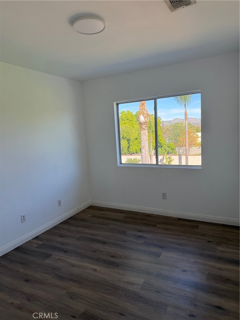 723 Ford Street Corona, CA 92879 - Photo 16 of 36 an empty room with wooden floor and windows