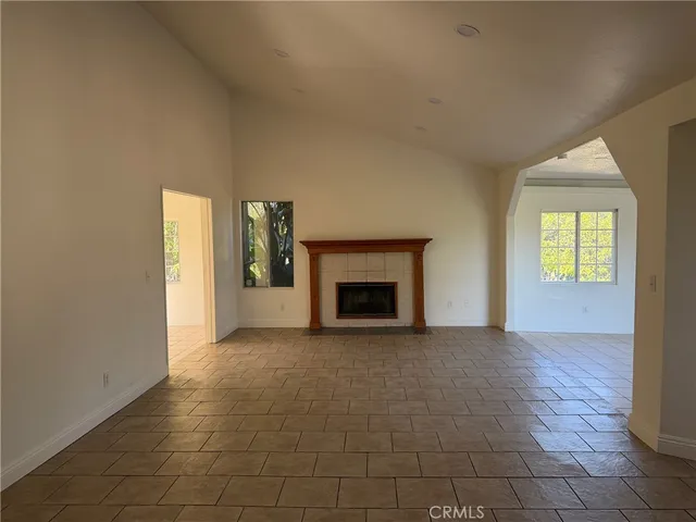 a view of an empty room with a fireplace and a window