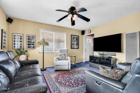 a living room with fireplace furniture and a rug