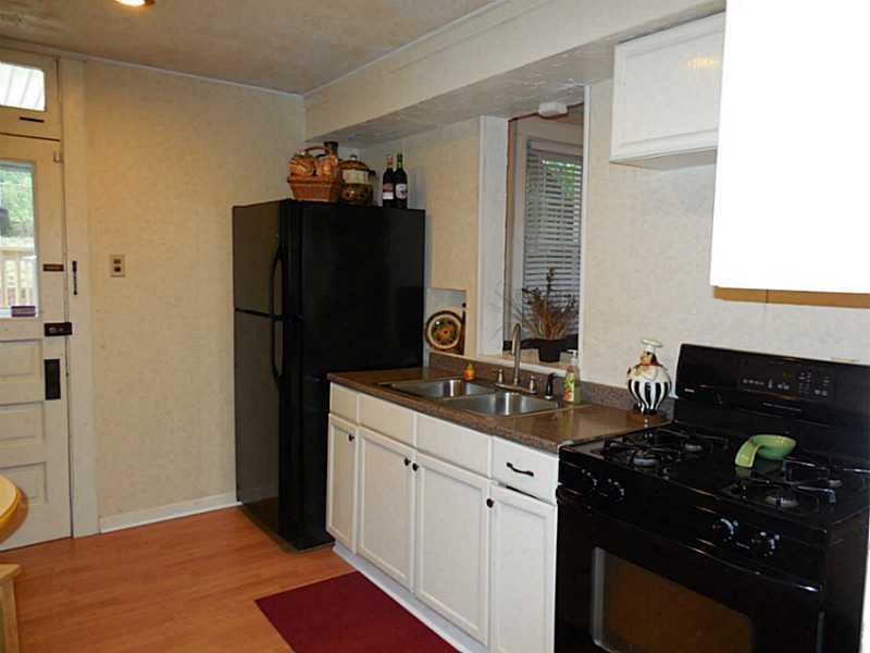 1301 Pine Hollow Road McKees Rocks, PA 15136 - Photo 6 of 24 Kitchen. The laminate flooring continues into the kitchen. Refrigerator and gas stove included. The pass through window is open to the family room.