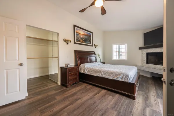 a spacious bedroom with a bed a dresser and a flat screen tv