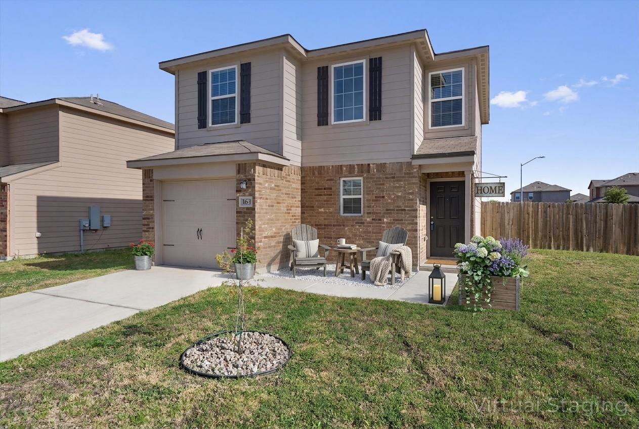 163 Niven Path, Unit 12K Jarrell, TX 76537 - Photo 3 of 31 Traditional-style house with brick siding, an attached garage, driveway, and a patio. VIRTUALLY STAGED