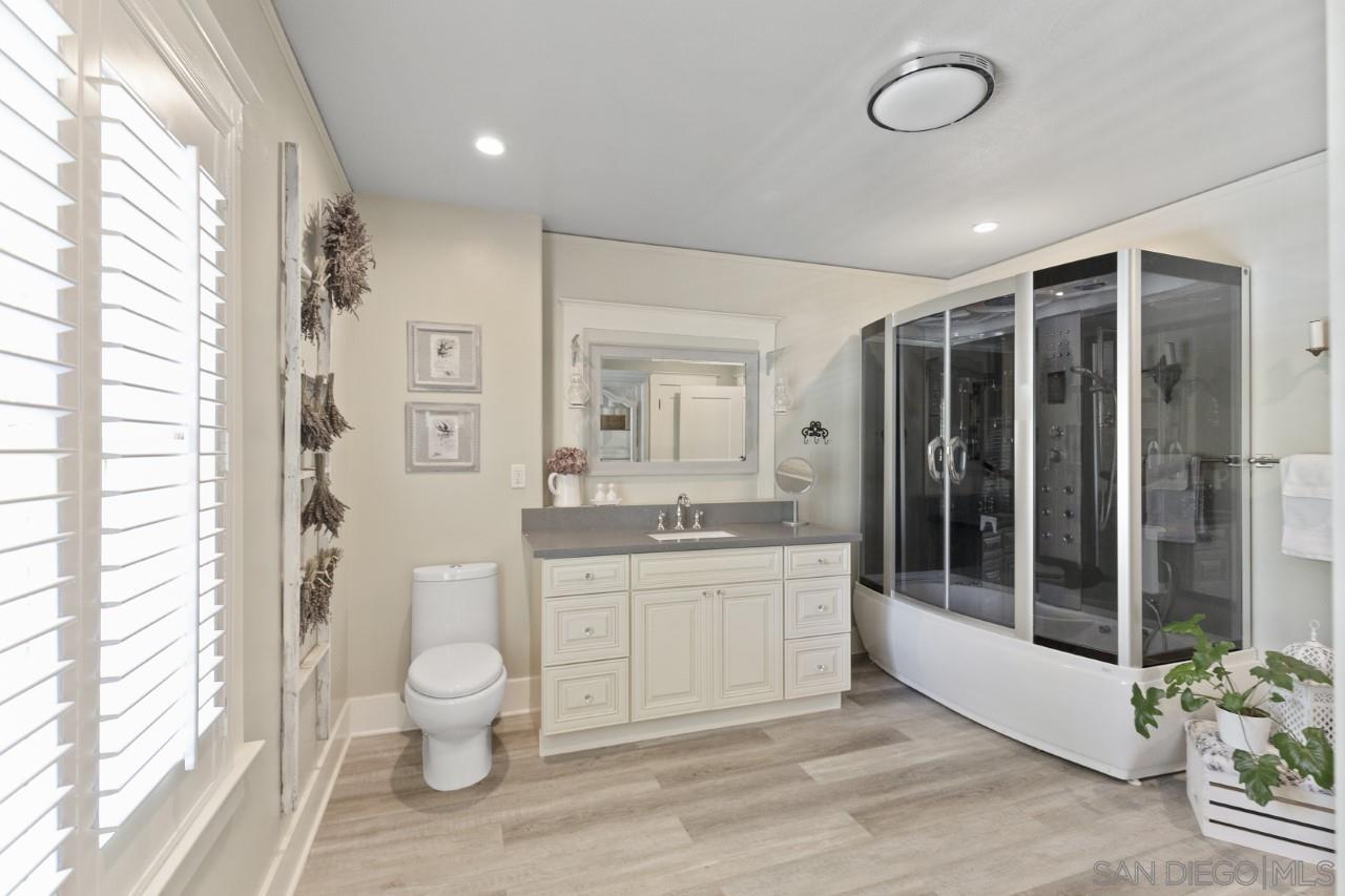 1122 Euclid Avenue Ontario, CA 91762 - Photo 21 of 51 a bathroom with a granite countertop sink a toilet a mirror and shower