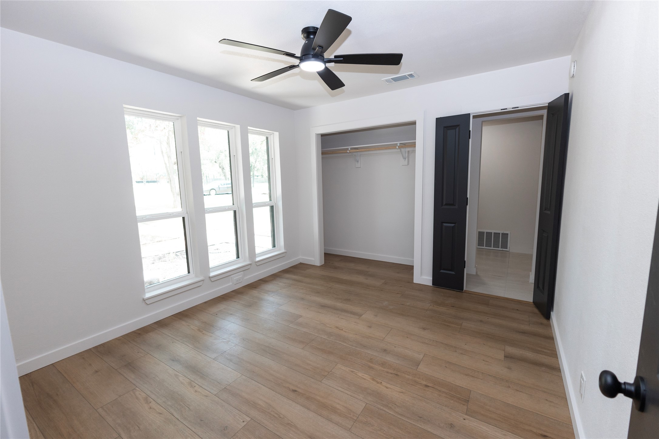 205 Bello Circle Georgetown, TX 78628 - Photo 9 of 36 A well-lit bedroom features durable hardwood flooring and a practical ceiling fan for year-round comfort.