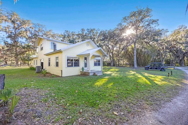 a view of a house with backyard and a tree