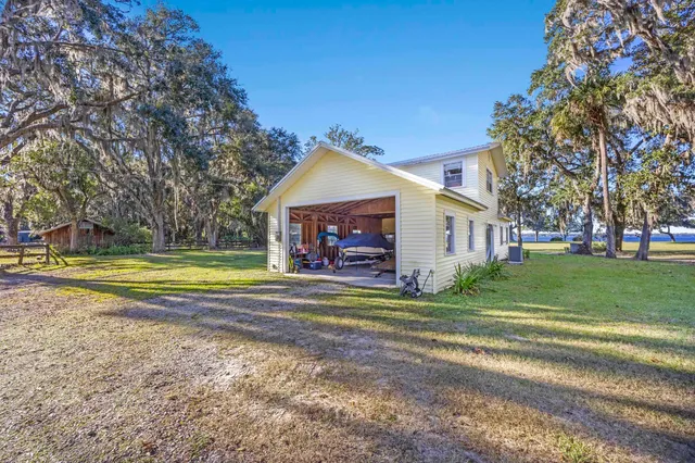 a view of a house with a big yard and large trees