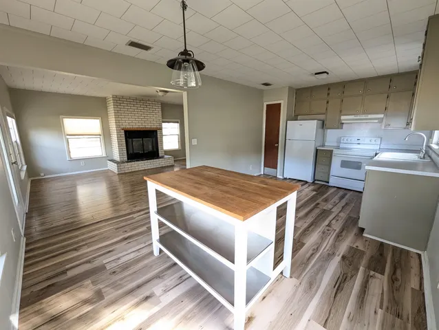 a kitchen with kitchen island a stove a sink and a refrigerator