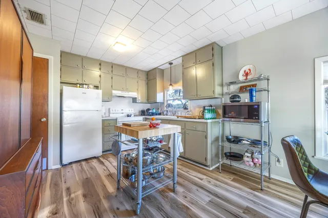 a kitchen with a table chairs refrigerator and a sink