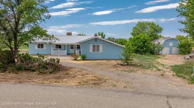 a front view of house with yard and trees around