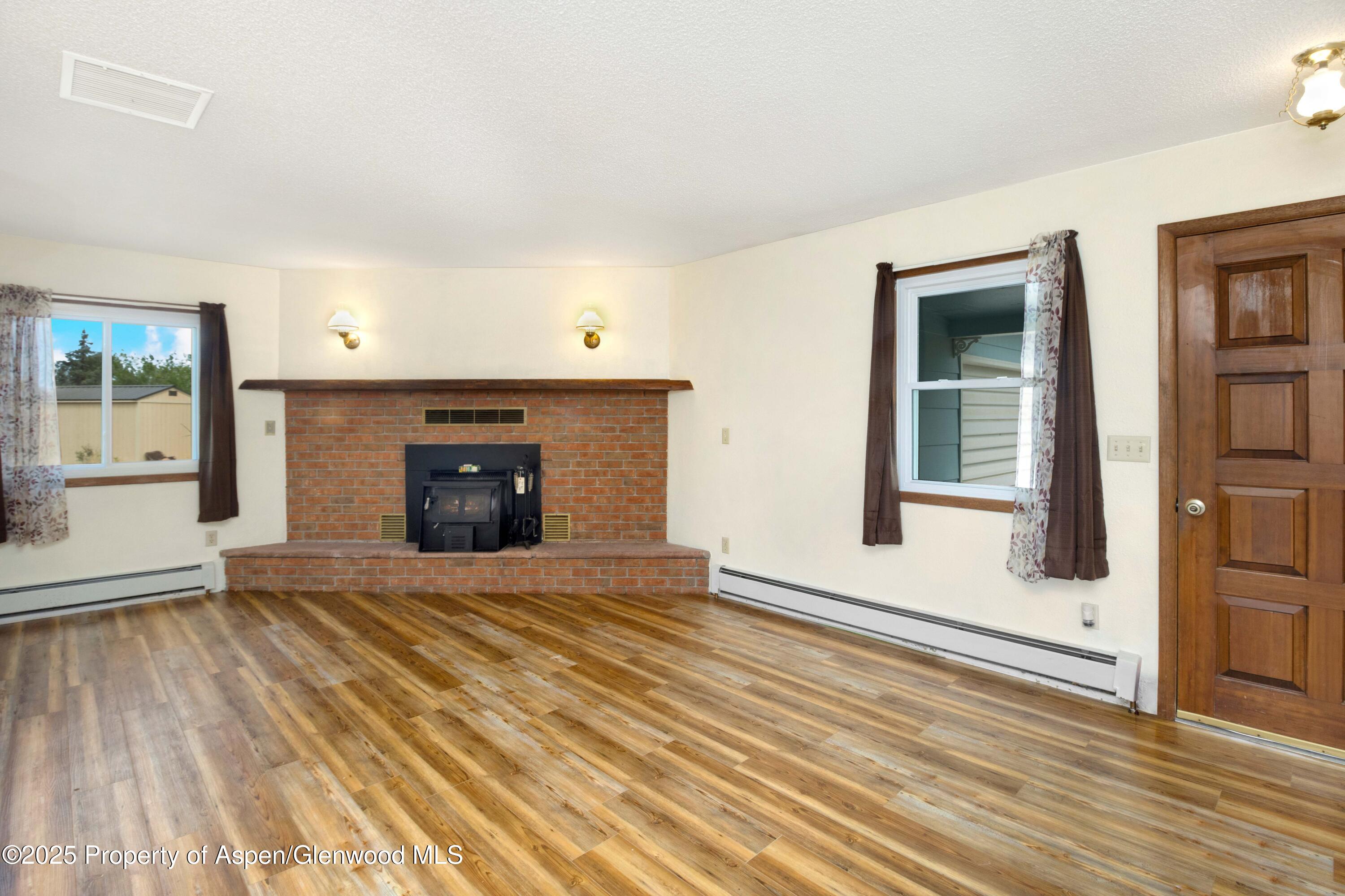 12303 West Spring Circle Eckert, CO 81418 - Photo 27 of 30 an empty room with wooden floor and a fireplace