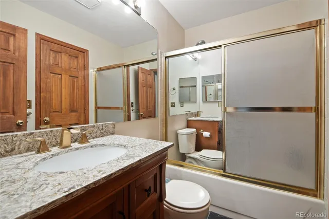 a bathroom with a granite countertop sink toilet and shower