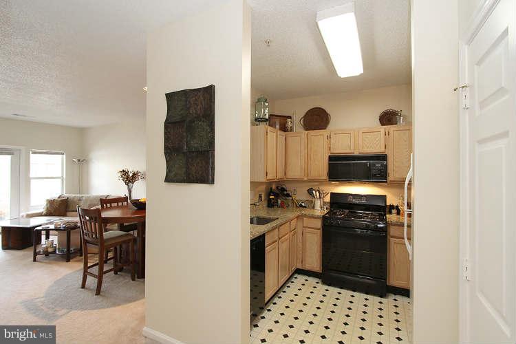 12009 Taliesin Place, Unit 14 Reston, VA 20190 - Photo 4 of 15 a kitchen with a sink stainless steel appliances and cabinets