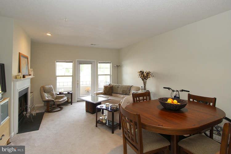 12009 Taliesin Place, Unit 14 Reston, VA 20190 - Photo 6 of 15 a view of a dining room with furniture a fireplace and wooden floor