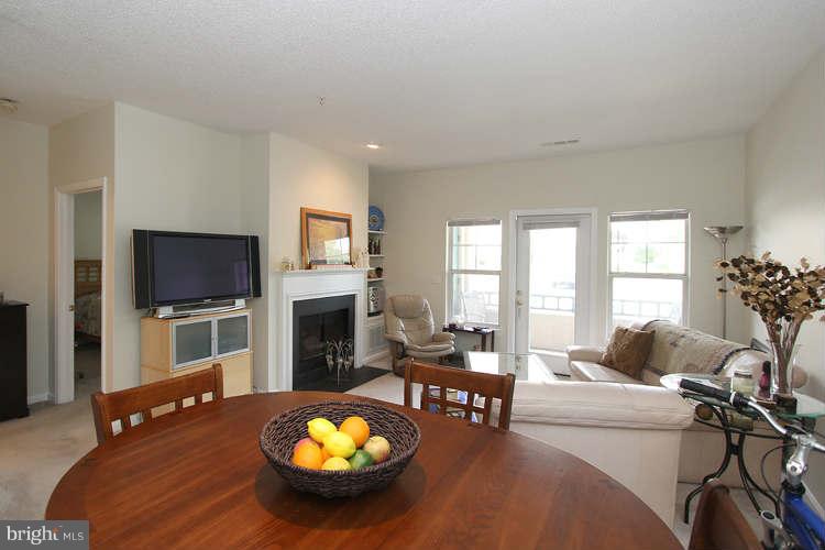 12009 Taliesin Place, Unit 14 Reston, VA 20190 - Photo 7 of 15 a living room with furniture a fireplace and a flat screen tv