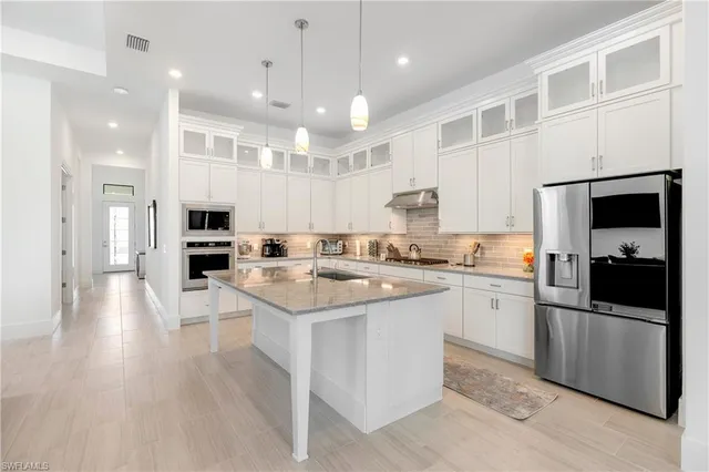 a kitchen with a sink stainless steel appliances and white cabinets