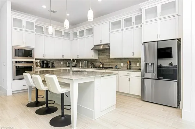 a kitchen with stainless steel appliances granite countertop a stove a sink a microwave and a refrigerator