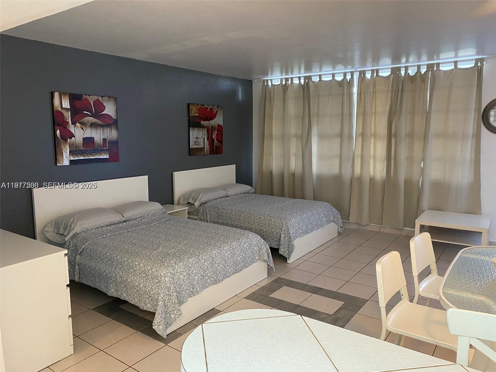 100 Lincoln Road, Unit 304 Miami Beach, FL 33139 - Photo 1 of 8 a bedroom with two beds and curtain