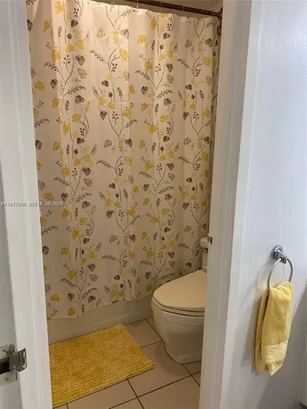 a bathroom with a toilet and a shower curtain