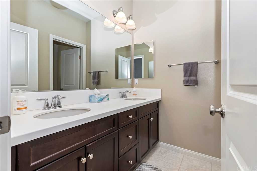 28212 Rustling Wind Circle Menifee, CA 92585 - Photo 19 of 28 a bathroom with a double vanity sink and a mirror