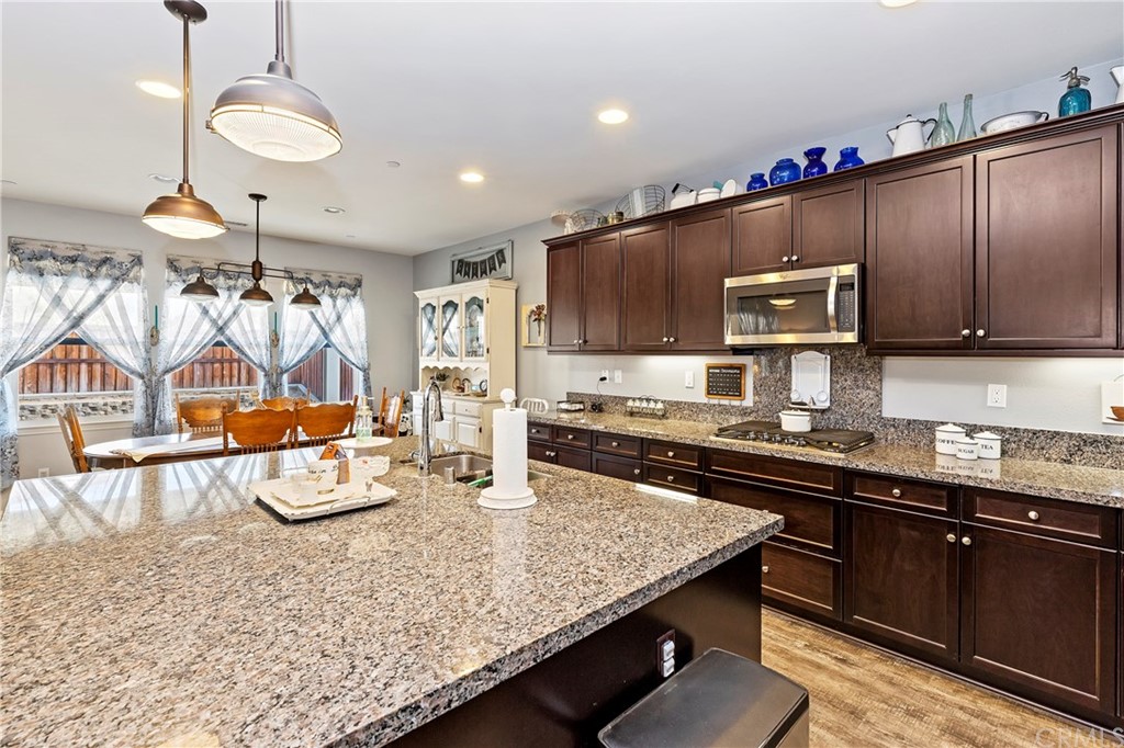 28212 Rustling Wind Circle Menifee, CA 92585 - Photo 10 of 28 a kitchen with stainless steel appliances granite countertop a sink a stove and a microwave
