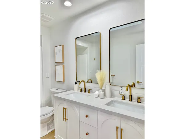 a bathroom with a sink a toilet and a mirror