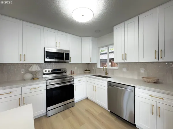 a kitchen with cabinets stainless steel appliances a sink and a counter top space