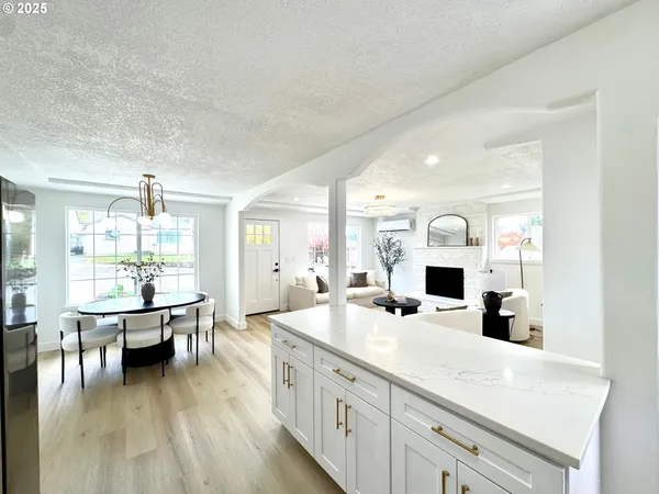 a large kitchen with kitchen island a large counter top space and stainless steel appliances