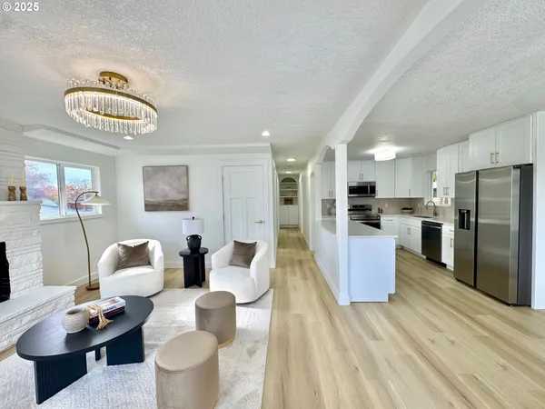 a living room with furniture wooden floor and kitchen view