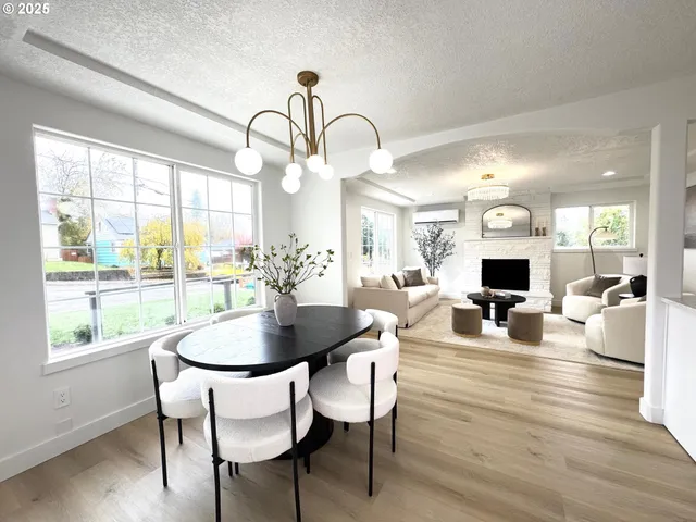 a dining room with wooden floor a chandelier a wooden table and chairs