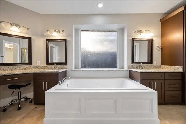a spacious bathroom with a bathtub a sink and a mirror
