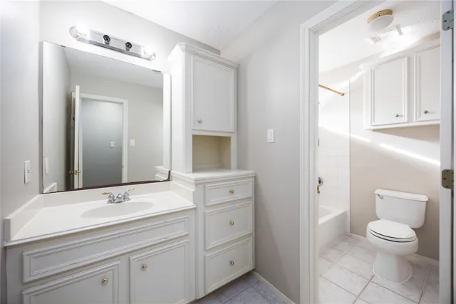 a bathroom with a toilet a sink a vanity and mirror