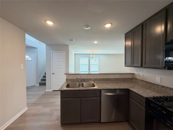 a kitchen with granite countertop a sink and cabinets