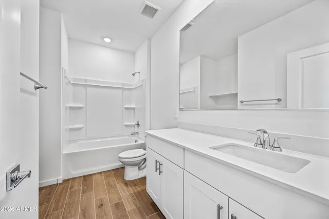 a bathroom with a sink a toilet and a large mirror