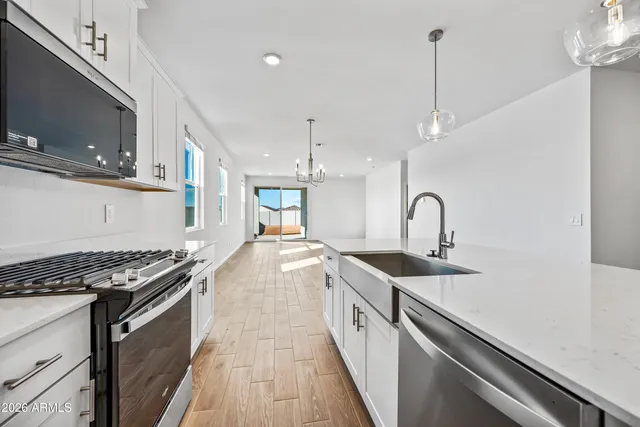 a kitchen with stainless steel appliances granite countertop a sink stove and cabinets