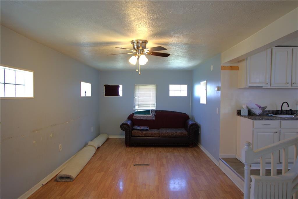 233 Allen Avenue Donora, PA 15033 - Photo 4 of 31 Large 25x11 Living Room just off Kitchen w/ Attractive Flooring, Glass Block Windows & Ceiling Fan Light