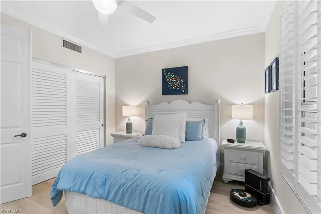 a bedroom with a bed and a lamp on the dresser