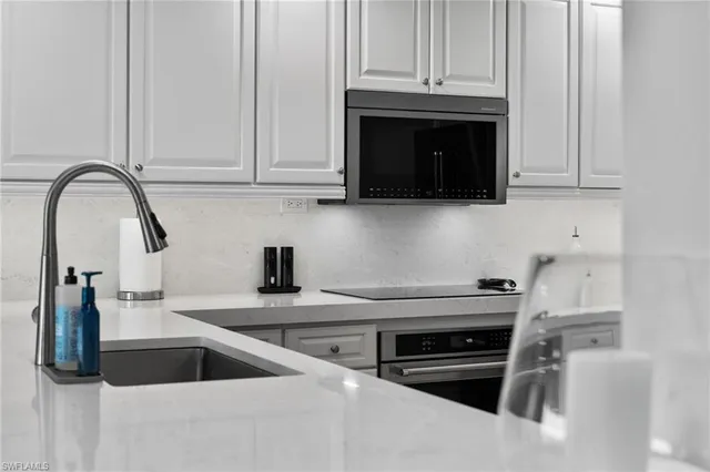 a kitchen with stainless steel appliances granite countertop a sink and a stove top oven