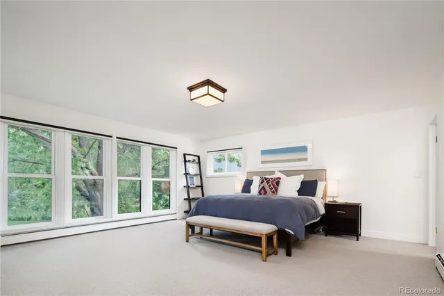 a spacious bedroom with a bed and a large window