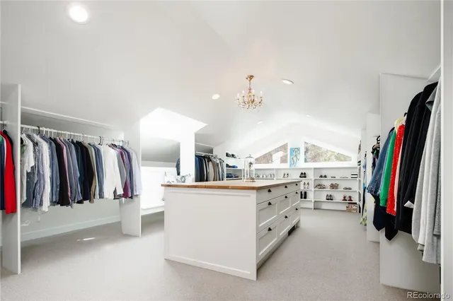 a view of walk in closet with clothes and shoes