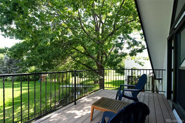 a view of a balcony with wooden floor and outdoor seating