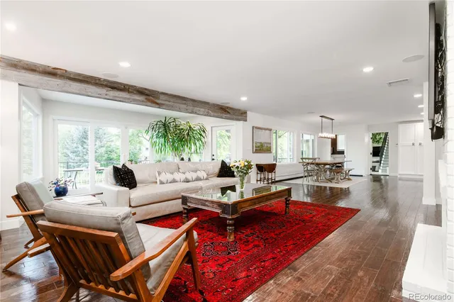 a living room with furniture a rug and a large window