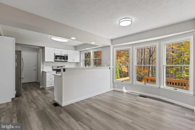 a kitchen with stainless steel appliances a refrigerator a stove a microwave and cabinets