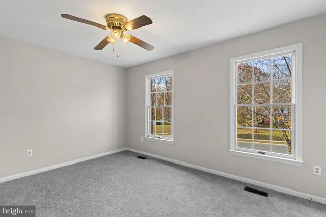 an empty room with a chandelier fan