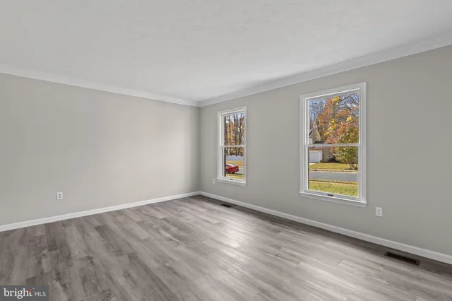 a view of an empty room with wooden floor