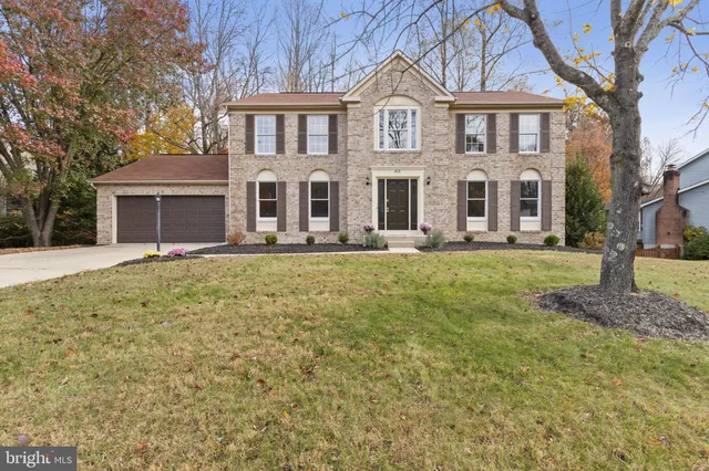 a view of house with yard and trees in the background