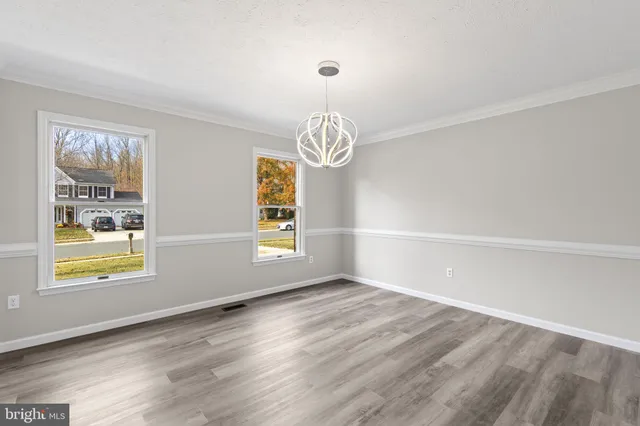 an empty room with windows & ceiling fan